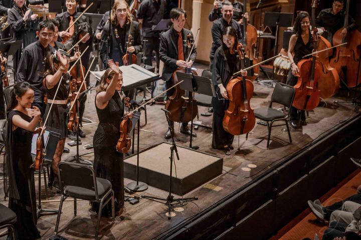 The orchestra taking a bow, strings raised