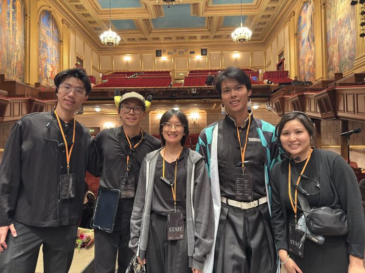 Five of the crew in staff lanyards and headsets on the Herbst Theatre stage at Legends After Dark, Aug 2026