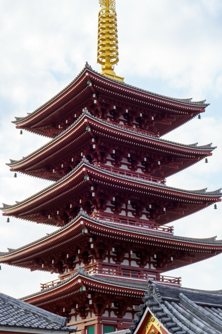 A red five-story pagoda against a white sky