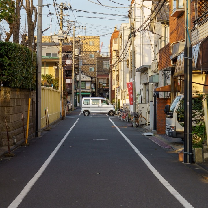 A narrow residential street under overhead power lines